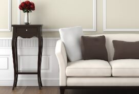 A white couch with pillows and a table in the background.