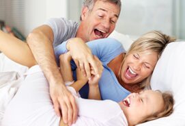 A man and woman laughing with a child.