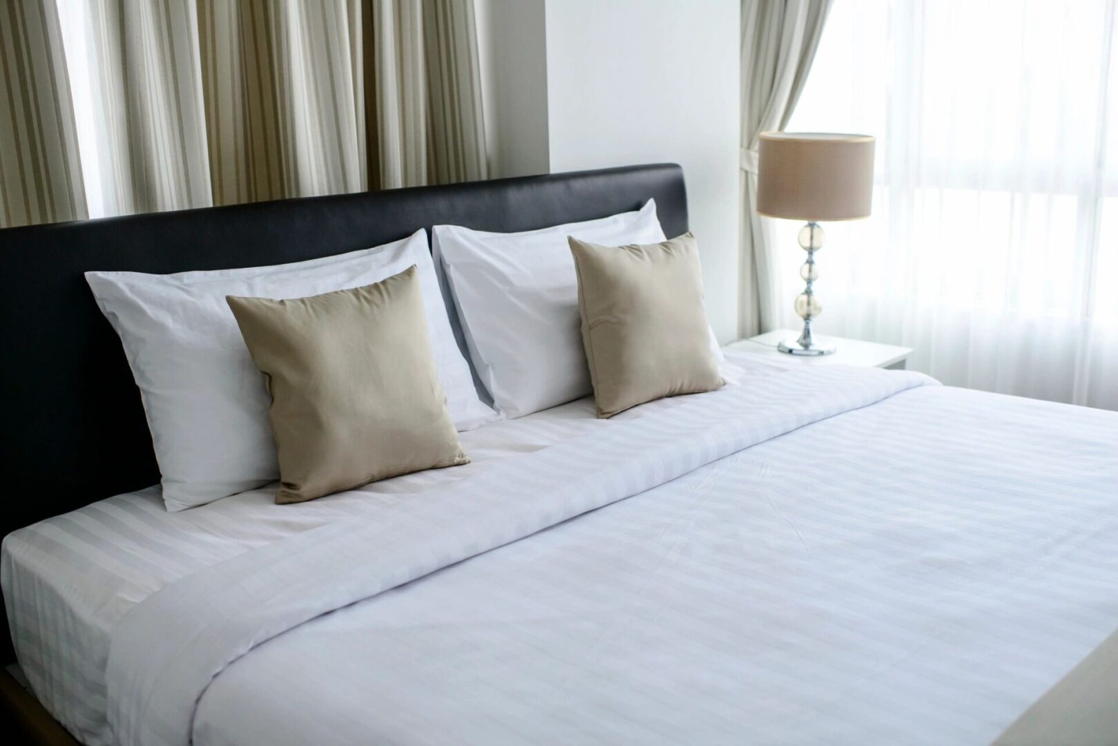 A bed with white sheets and pillows on it