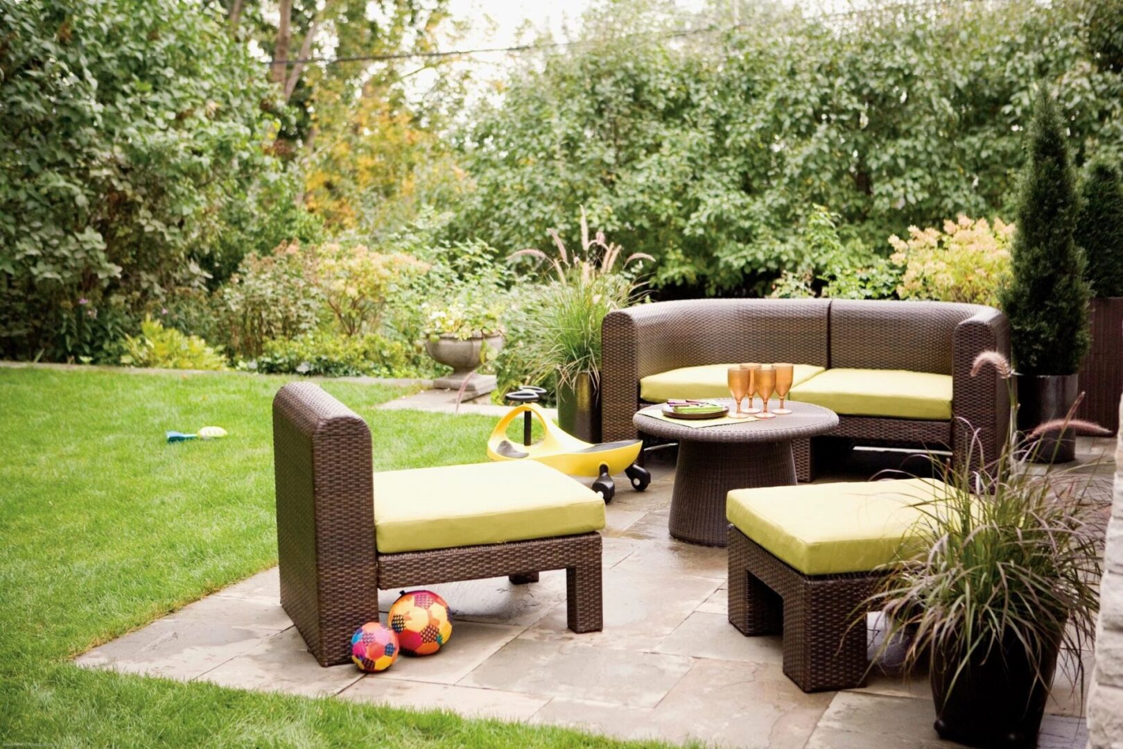 A patio with furniture and trees in the background.